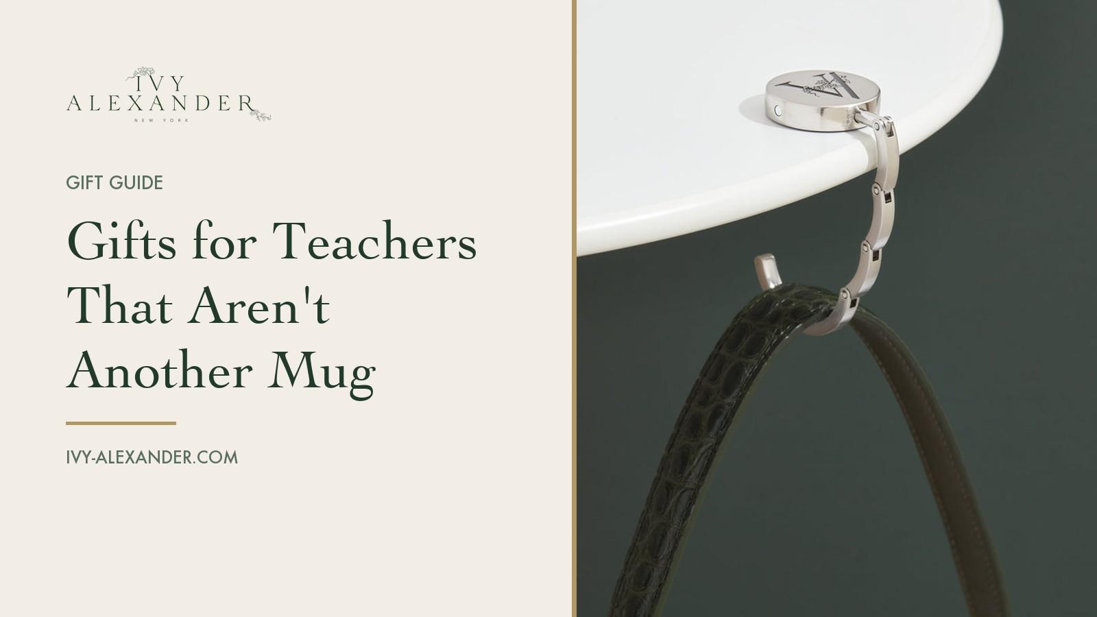 The Ivy Alexander Grace hook in brushed rhodium hanging a dark green strap from the edge of a white table, beside the title Gifts for Teachers That Aren't Another Mug.